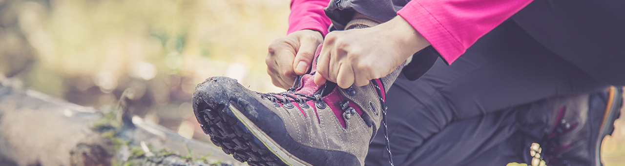 Randonneur sur un sentier de montagne portant des chaussettes de randonnée Wrightsock anti-ampoules.